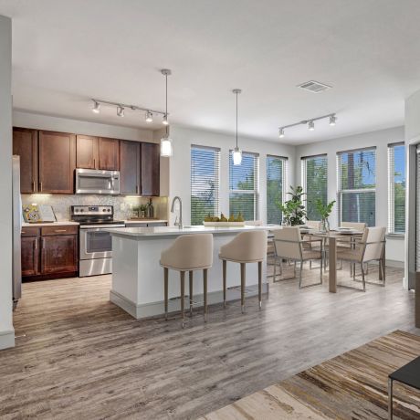 Enclave at the Dominion Modern open-concept kitchen and living area with a dining table, island, and large windows.